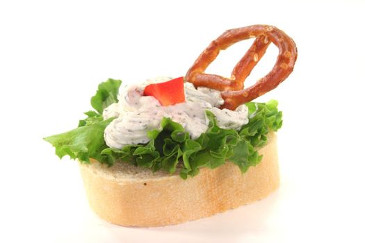 Canap� with lettuce, cheese, peppers and a pretzel on a white background