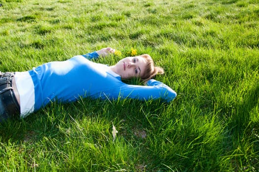 beautiful girl lying on the green grass