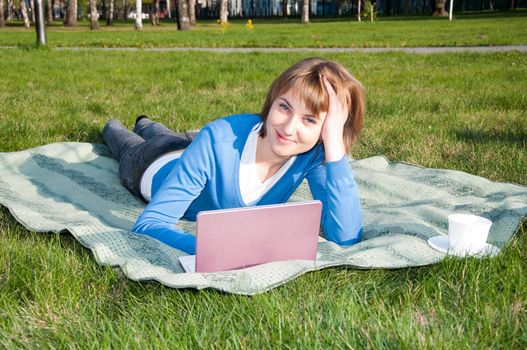 beautiful girl working on laptop in the park