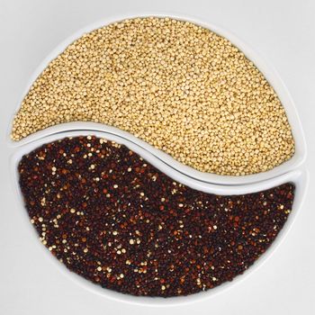 Raw red and white quinoa grains in two bowls forming a circle 