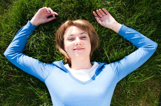 beautiful girl lying on the green grass