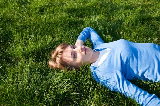 beautiful girl lying on the green grass