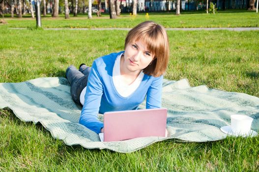 beautiful girl working on laptop in the park
