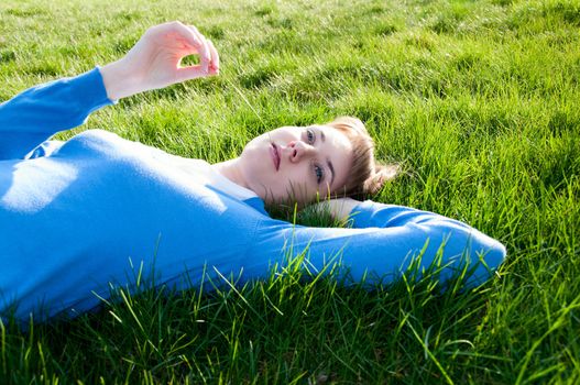 beautiful girl lying on the green grass