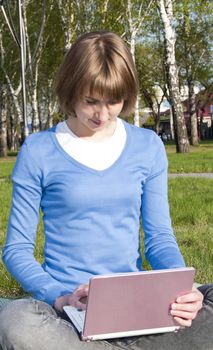 girl is working on a laptop in the park