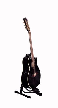 Black guitar on a stand on the white background
