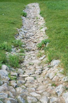 old dried-up stone-lined river-bed on a hill slope