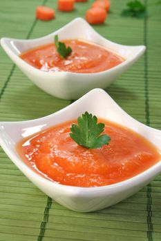 a bowl of carrot soup with fresh parsley