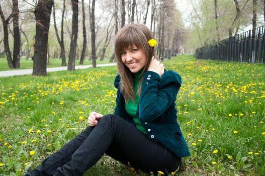 young girl in a park sitting on grass