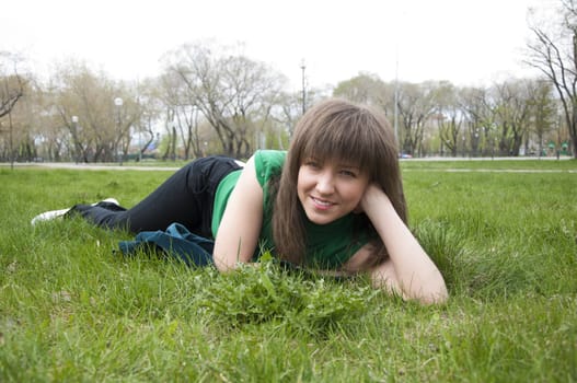 young girl lying on the grass in the park