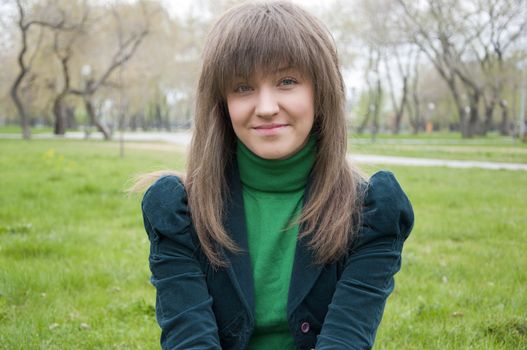 young girl in a park sitting on grass