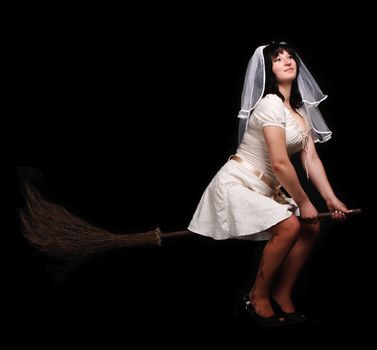 bride in white wedding dress on a broom. Girl with big breasts