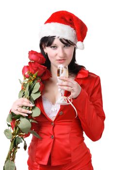 Portrait of a beautiful young woman in a red suit and hat of Santa Claus with red roses and champagne on the white background
