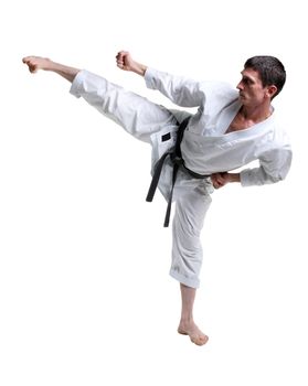 Karate. Man in a kimono hits foot on the white background
