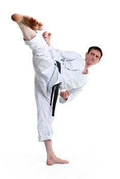 Karate. Man in a kimono hits foot on the white background
