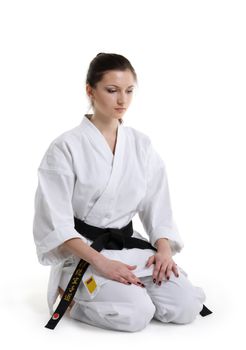 Karate. Young girl in a kimono with a white background
