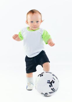 Cute 1 years old boy in sports form with a soccer ball in the studio