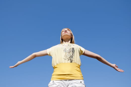 portrait young woman having stretched hands aspires in the sky