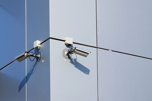 A security cameras on the side of an office building.