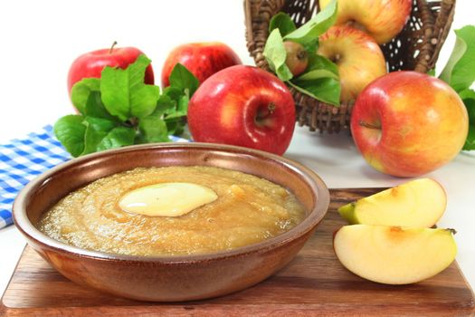 a bowl of applesauce with vanilla sauce and fresh apples