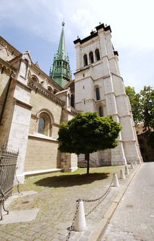 South facade of protestant Saint-Peter's cathedral with its green bell-tower in Geneva, Switzerland. The construction started in 1160 and lasted about one century. After that, it's been modified several times, sometimes because of fire. At XVI century, when the protestant Reformation advented, the inside was modified to have less decoration.