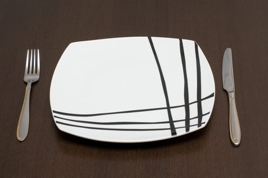 Modern place setting: fork, knife, plate