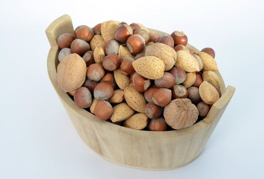 Hazelnuts, walnuts and almonds in a wood basket isolated on white background