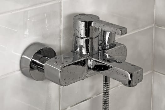 Modern metallic faucet with water drops