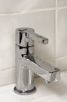 Modern metallic faucet with water drops