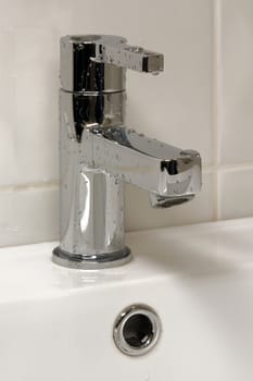 Modern metallic faucet with water drops