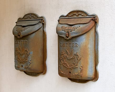 Old rusty metal mailboxes on wall