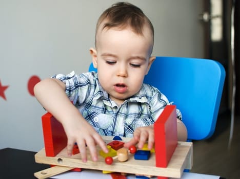 Little boy playing with wooden toy