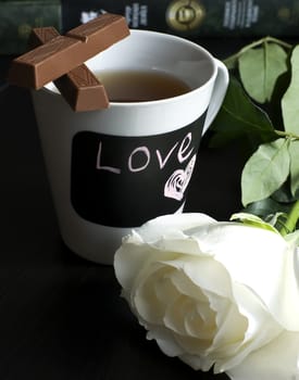 cup of tea with chocolate and rose