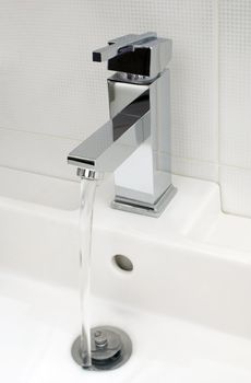 Closeup of modern bathroom tap, flowing tap water