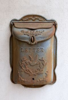 Old rusty metal mailbox on wall