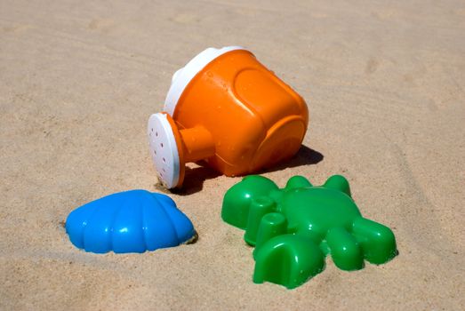 Colorful children's toys lying on the sand