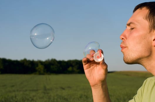 Profile of a young man blowing bubbles