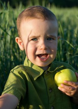 Portrait of little boy with green apple