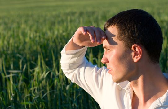 Portrait of a young man in green field