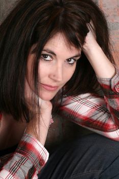 Beautiful brunette woman against a brick wall background