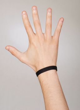 conceptual picture of a photographer hand with bracelet trying to catch the light that come from the background