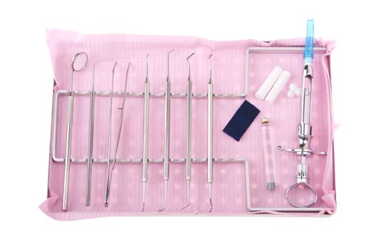 dentistry kit in a tray on pink bib (surgery instruments, articulation paper, cotton rolls/wools, cartridge and syringe)