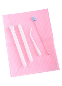 different types of surgical aspirators (single use) on a pink bib (isolated on white background)