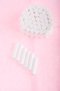 dental cotton rolls on a pink bib (dentistry equipment)