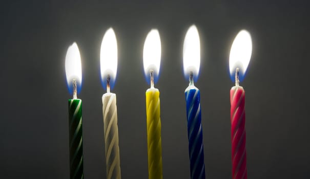 multi-colored birthday candles on dark background