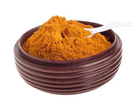 curry powder, mix of indian spices on a vintage wooden bowl with spoon (isolated on white background) 