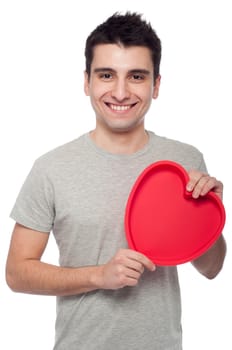 lovely portrait of a young man holding a red heart (isolated on white background)