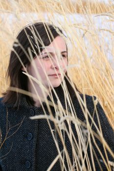 Beautiful brunette female amongst long wild grass