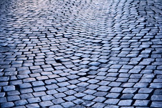 Rough texture of wet cobblestones, old side-street