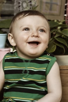 Cute baby boy outside in the garden wearing green outfit